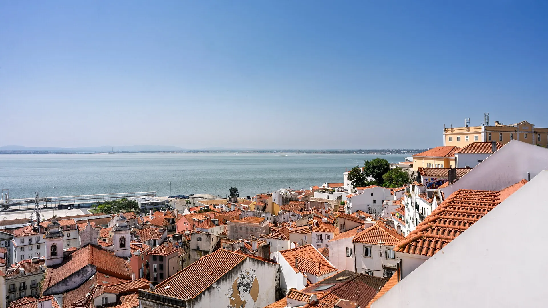 Rooftops of Alfama above the Tagus river in Lisbon at sunset