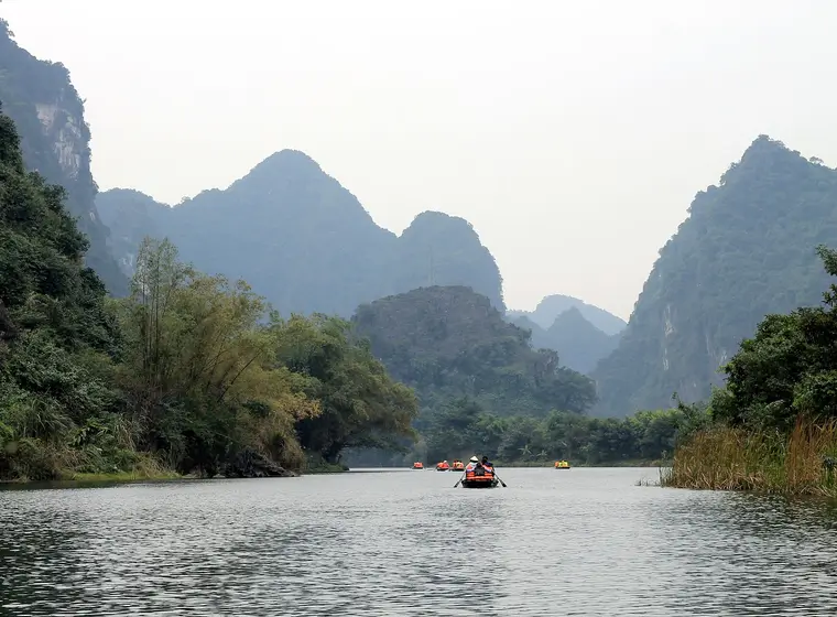 Rowing boat entering a river cave in Ninh Binh, Vietnam